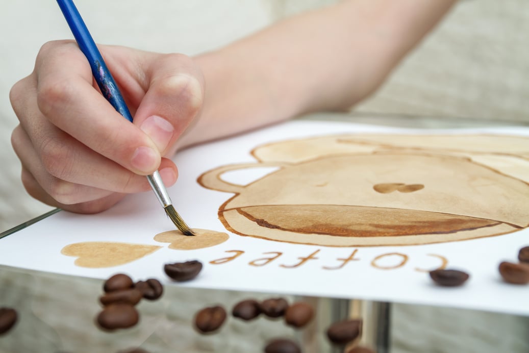 Coffee drawings. Girl draws a coffee cup using coffee instead of paints